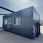 Harmaan värinen toimistokontti, jossa lisäturvaa tuovat kalteri-ikkunat.